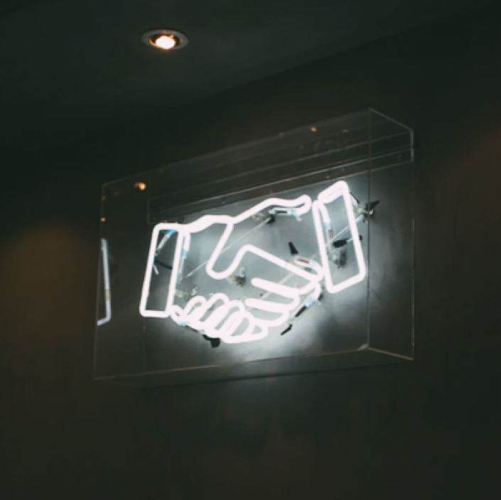 Neon sign of a handshake